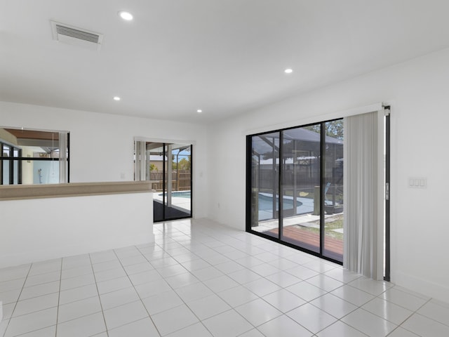 1138 SW Gardena Ave, Port Saint Lucie, FL 34953 - empty room featuring healthy amount of natural light, recessed lighting, and light tile patterned floors