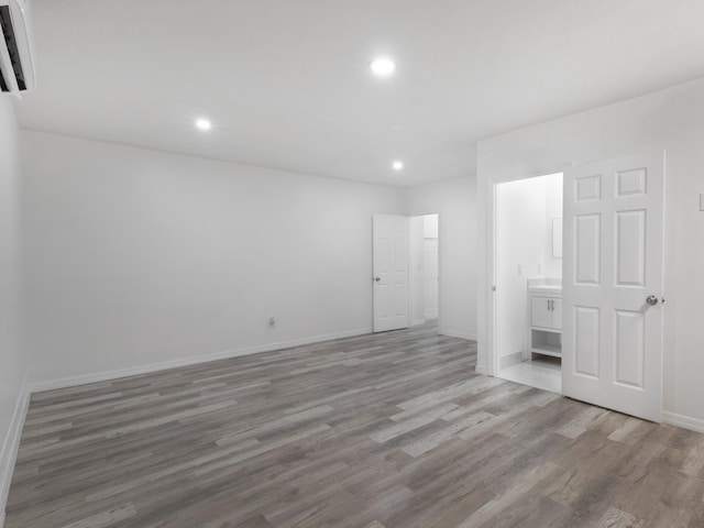1138 SW Gardena Ave, Port Saint Lucie, FL 34953 - unfurnished bedroom with wood finished floors, recessed lighting, baseboards, and ensuite bathroom