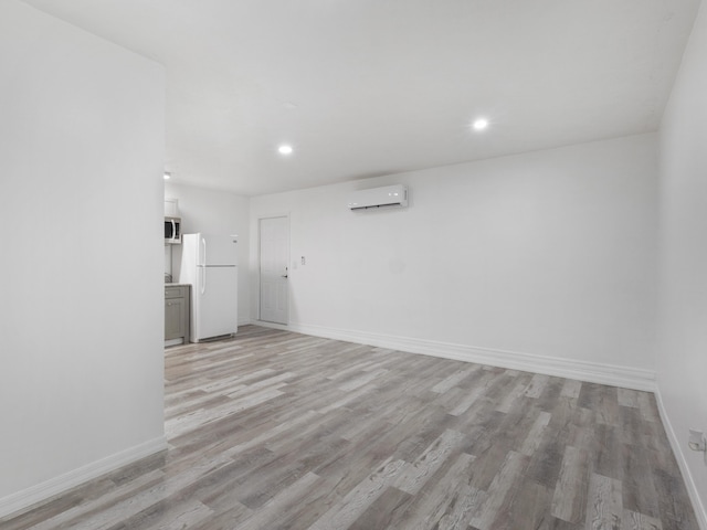 1138 SW Gardena Ave, Port Saint Lucie, FL 34953 - unfurnished living room with a wall mounted air conditioner, light wood-style flooring, baseboards, and recessed lighting