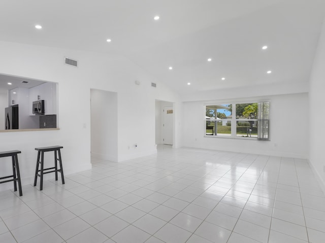 1138 SW Gardena Ave, Port Saint Lucie, FL 34953 - unfurnished living room with light tile patterned floors, lofted ceiling, recessed lighting, and baseboards