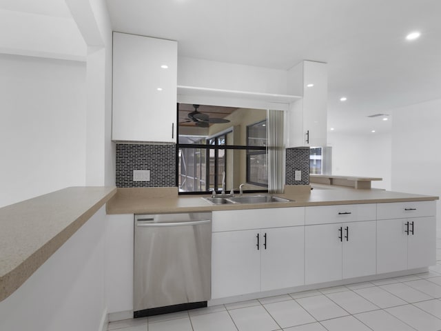 1138 SW Gardena Ave, Port Saint Lucie, FL 34953 - kitchen with stainless steel dishwasher, white cabinets, backsplash, a sink, and ceiling fan
