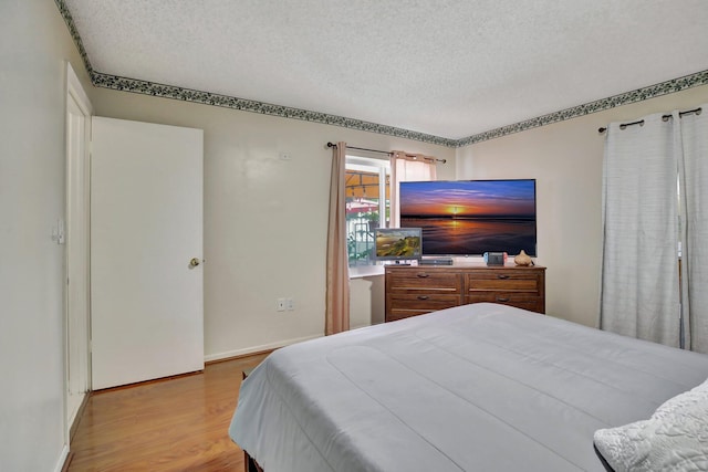 1266 NW 126th Ter, Sunrise, FL 33323 - bedroom with a textured ceiling, wood finished floors, and baseboards