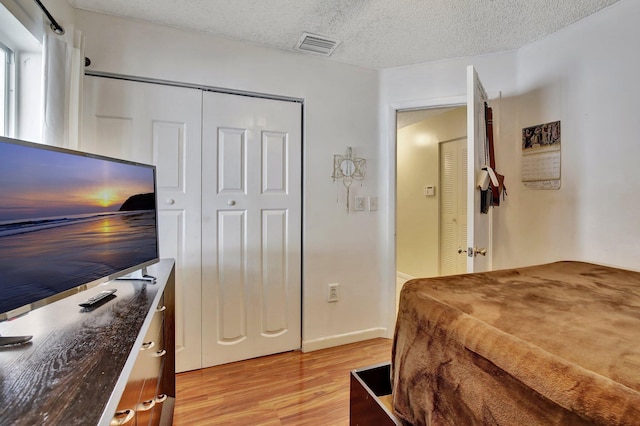1266 NW 126th Ter, Sunrise, FL 33323 - bedroom featuring light wood-style floors, a textured ceiling, a closet, and baseboards