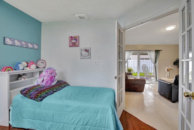 1266 NW 126th Ter, Sunrise, FL 33323 - tiled bedroom with french doors and a textured ceiling