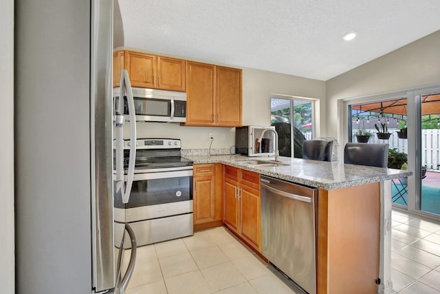 1266 NW 126th Ter, Sunrise, FL 33323 - kitchen featuring stainless steel appliances, a sink, a peninsula, light stone counters, and light tile patterned floors