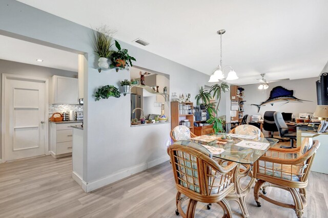 2115 SW 22nd St, Boynton Beach, FL 33426 - dining space featuring light wood finished floors, a ceiling fan, a chandelier, and baseboards