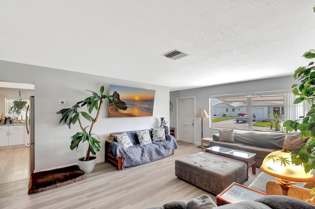 2115 SW 22nd St, Boynton Beach, FL 33426 - living room featuring light wood finished floors, baseboards, and a textured ceiling