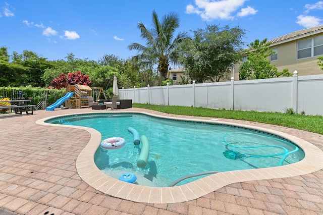 561 Peppergrass Run, Royal Palm Beach, FL 33411 - view of pool featuring a fenced backyard, a patio, and a playground