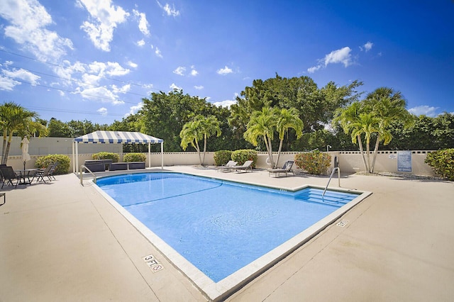 5936 Morningstar Cir Unit 201, Delray Beach, FL 33484 - community pool with fence, a patio area, and view of scattered trees