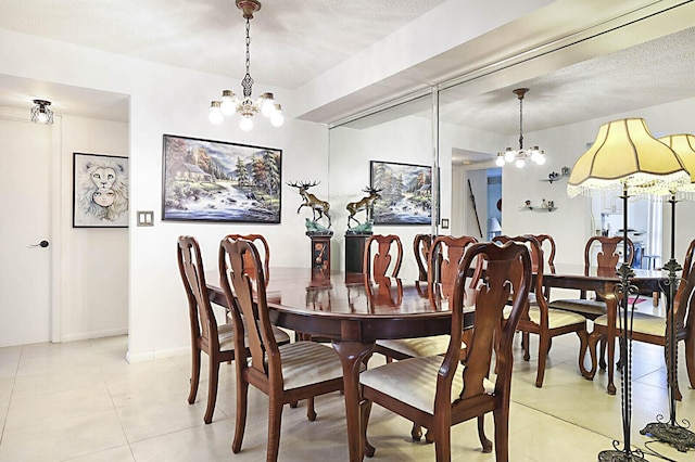 5936 Morningstar Cir Unit 201, Delray Beach, FL 33484 - dining space featuring a chandelier, light tile patterned floors, and baseboards