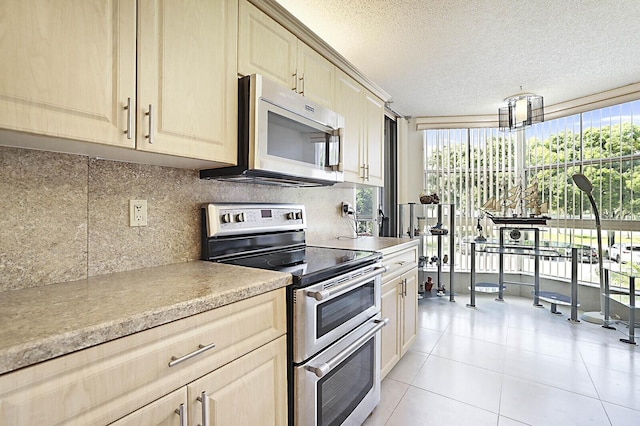5936 Morningstar Cir Unit 201, Delray Beach, FL 33484 - kitchen with stainless steel appliances, light countertops, decorative backsplash, a textured ceiling, and light tile patterned flooring