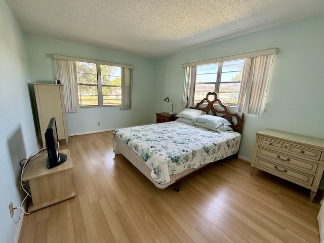 2060 Newport N, Deerfield Beach, FL 33442 - bedroom with multiple windows, light wood-style flooring, a textured ceiling, and baseboards