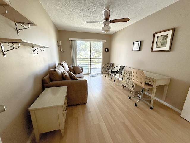 2060 Newport N, Deerfield Beach, FL 33442 - living area featuring light wood-style floors, ceiling fan, a textured ceiling, and baseboards