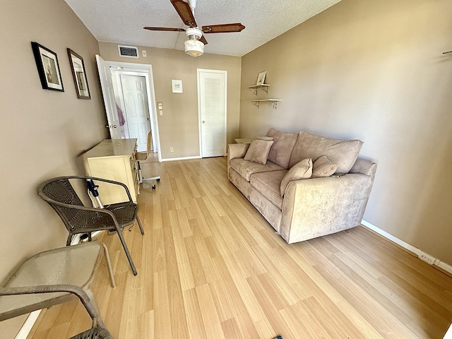 2060 Newport N, Deerfield Beach, FL 33442 - living room featuring a ceiling fan, light wood-style floors, baseboards, and a textured ceiling