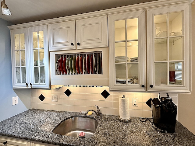 2060 Newport N, Deerfield Beach, FL 33442 - kitchen featuring backsplash, a sink, glass insert cabinets, and dark stone countertops