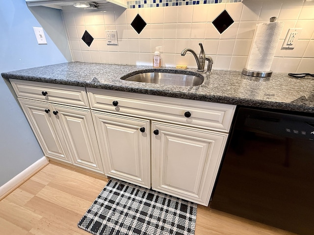 2060 Newport N, Deerfield Beach, FL 33442 - kitchen featuring black dishwasher, a sink, light wood-style floors, and backsplash