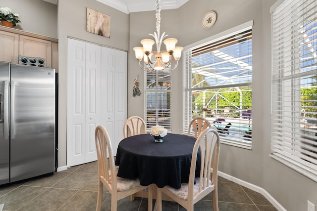 1629 SE Tradition Trce, Stuart, FL 34997 - dining area featuring dark tile patterned flooring, a chandelier, crown molding, baseboards, and healthy amount of natural light