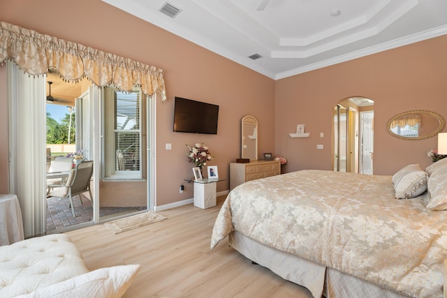 1629 SE Tradition Trce, Stuart, FL 34997 - bedroom with access to outside, arched walkways, a raised ceiling, light wood-type flooring, and crown molding
