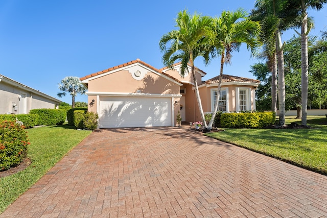 1629 SE Tradition Trce, Stuart, FL 34997 - mediterranean / spanish home featuring decorative driveway, a garage, a front yard, stucco siding, and a tiled roof