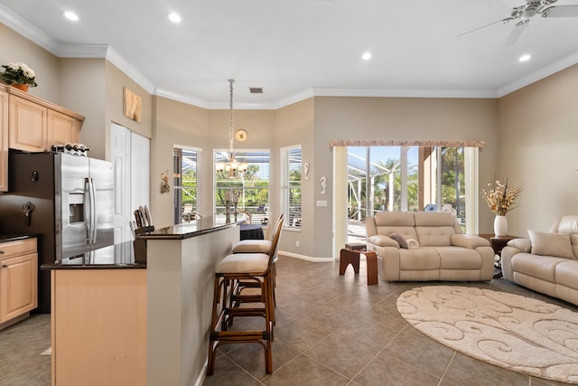 1629 SE Tradition Trce, Stuart, FL 34997 - kitchen with dark countertops, recessed lighting, light brown cabinets, a breakfast bar, and a chandelier