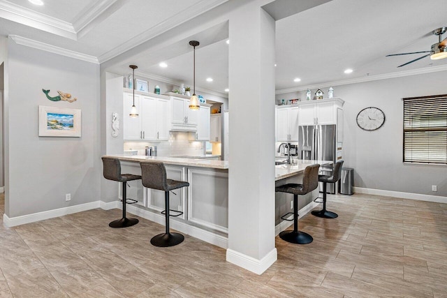 12209 Boca Reserve Ln, Boca Raton, FL 33428 - kitchen featuring ornamental molding, a breakfast bar, white cabinets, backsplash, and a ceiling fan