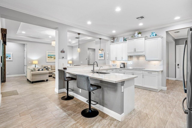 12209 Boca Reserve Ln, Boca Raton, FL 33428 - kitchen featuring a sink, a breakfast bar, white cabinets, light stone countertops, and freestanding refrigerator