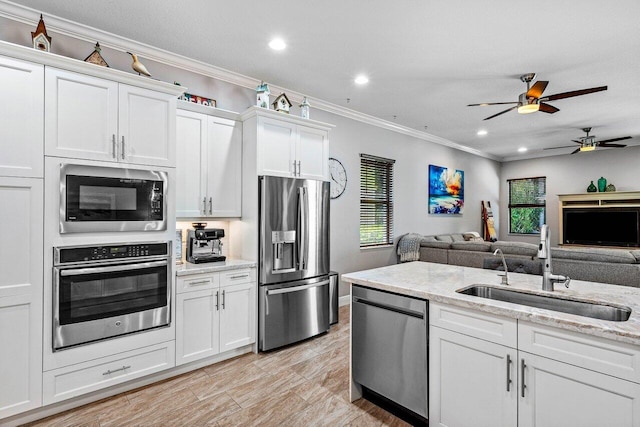 12209 Boca Reserve Ln, Boca Raton, FL 33428 - kitchen featuring appliances with stainless steel finishes, a sink, crown molding, ceiling fan, and open floor plan