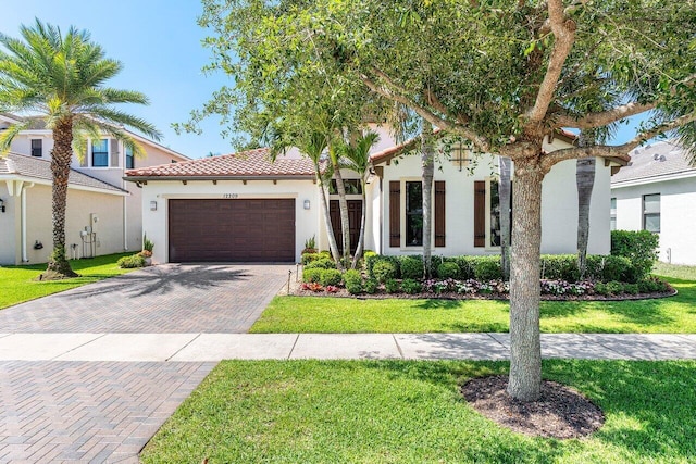 12209 Boca Reserve Ln, Boca Raton, FL 33428 - mediterranean / spanish-style home featuring an attached garage, decorative driveway, stucco siding, and a front yard