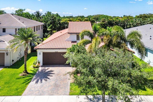 12209 Boca Reserve Ln, Boca Raton, FL 33428 - view of front of home featuring a tiled roof, an attached garage, stucco siding, decorative driveway, and a front lawn