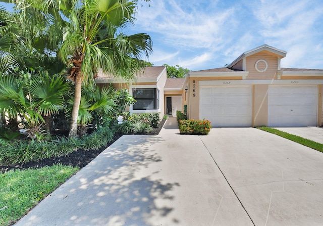 8269 Springtree Rd, Boca Raton, FL 33496 - view of front of home featuring a garage, concrete driveway, and stucco siding