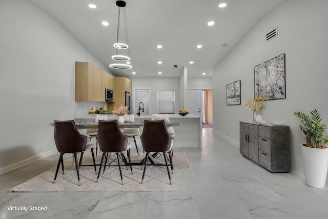 8269 Springtree Rd, Boca Raton, FL 33496 - kitchen with stainless steel microwave, recessed lighting, light countertops, light brown cabinets, and modern cabinets