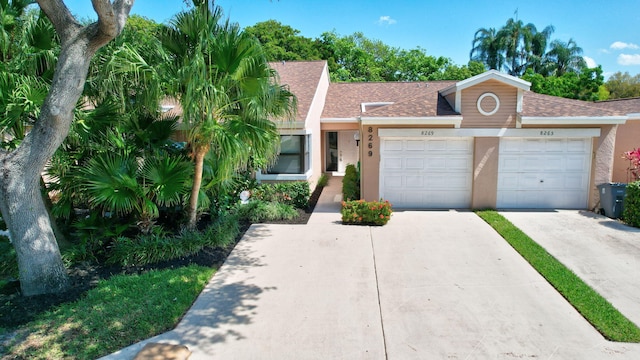 8269 Springtree Rd, Boca Raton, FL 33496 - view of front of property featuring a garage, driveway, roof with shingles, and stucco siding