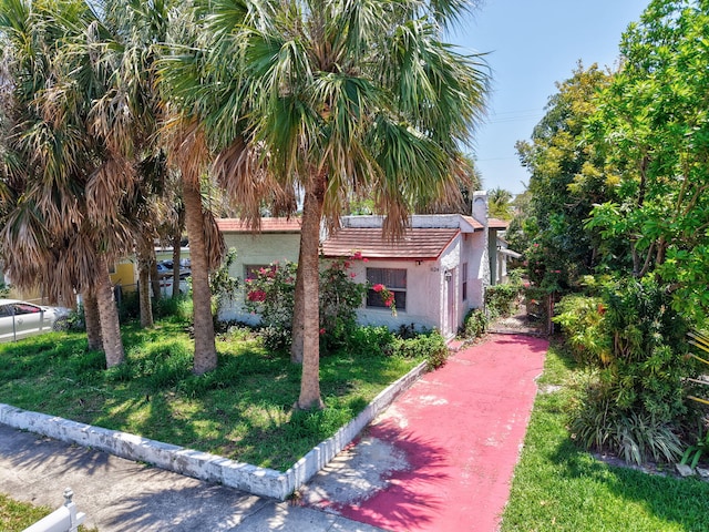624 51st St, West Palm Beach, FL 33407 - view of front of home with stucco siding and a chimney