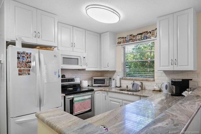 2600 SE Ocean Blvd Unit H7, Stuart, FL 34996 - kitchen with white appliances, a sink, white cabinets, and tasteful backsplash