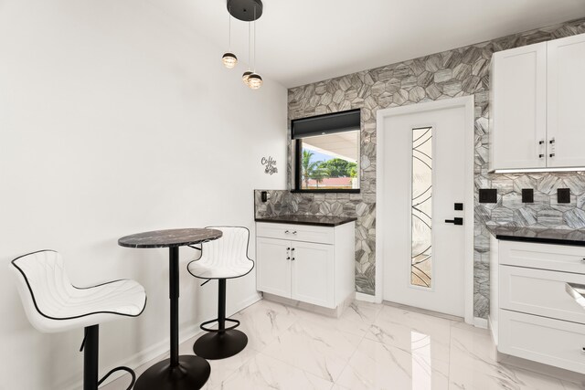 1428 N M St, Lake Worth Beach, FL 33460 - kitchen featuring decorative backsplash, light marble finish flooring, white cabinets, and dark countertops