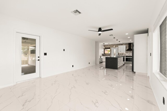 1428 N M St, Lake Worth Beach, FL 33460 - unfurnished living room with healthy amount of natural light, ceiling fan, recessed lighting, light marble finish flooring, and baseboards