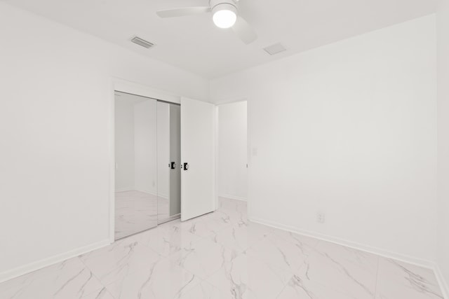 1428 N M St, Lake Worth Beach, FL 33460 - unfurnished bedroom featuring light marble finish floors, baseboards, a closet, and ceiling fan