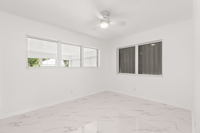 1428 N M St, Lake Worth Beach, FL 33460 - spare room featuring light marble finish flooring, baseboards, and ceiling fan