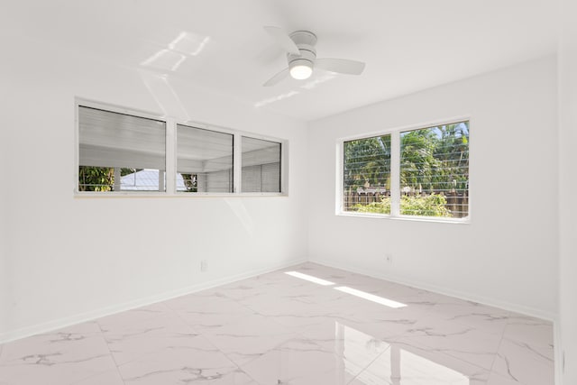 1428 N M St, Lake Worth Beach, FL 33460 - spare room with baseboards, marble look tile flooring, and ceiling fan