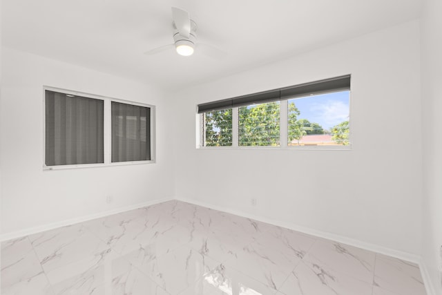 1428 N M St, Lake Worth Beach, FL 33460 - unfurnished room featuring marble look tiles, baseboards, and ceiling fan