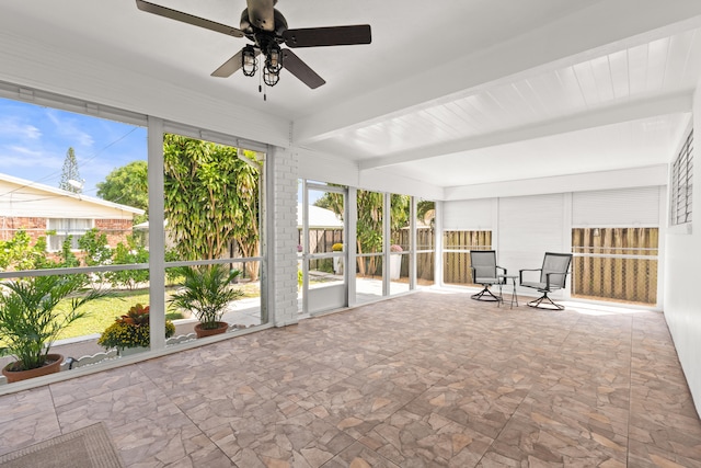 1428 N M St, Lake Worth Beach, FL 33460 - unfurnished sunroom featuring stone finish flooring, a ceiling fan, and beam ceiling