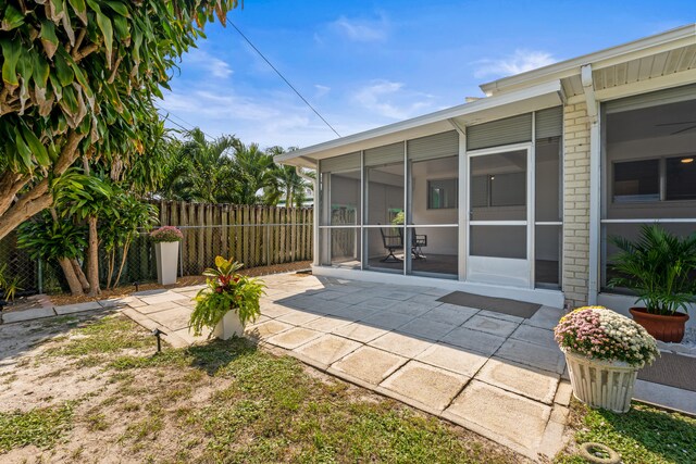 1428 N M St, Lake Worth Beach, FL 33460 - rear view of house with a sunroom, a patio, and brick siding