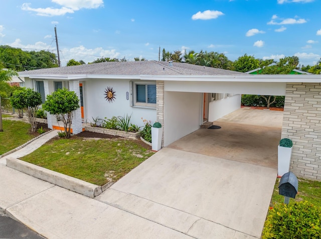 1428 N M St, Lake Worth Beach, FL 33460 - single story home featuring stucco siding, concrete driveway, a front lawn, an attached carport, and roof with shingles