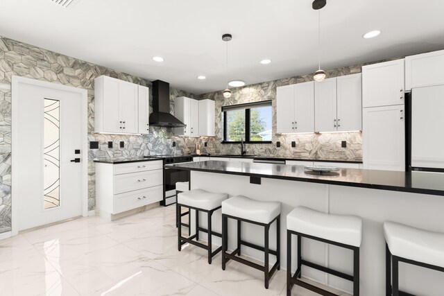 1428 N M St, Lake Worth Beach, FL 33460 - kitchen with wall chimney exhaust hood, electric range, a breakfast bar, a sink, and dark countertops