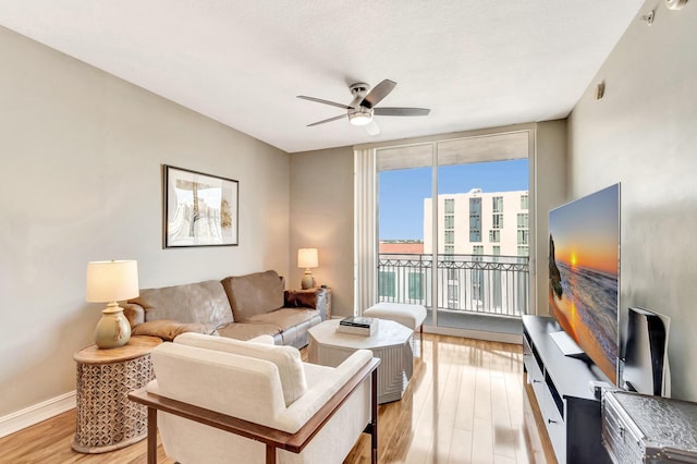 550 Okeechobee Blvd Unit 821, West Palm Beach, FL 33401 - living area with ceiling fan, light wood-style floors, baseboards, and a wall of windows