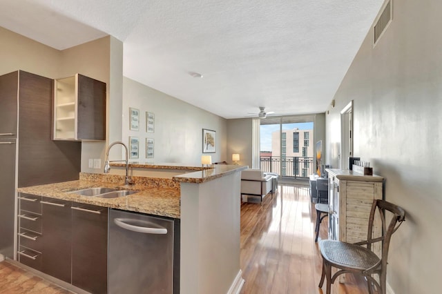 550 Okeechobee Blvd Unit 821, West Palm Beach, FL 33401 - kitchen featuring a sink, a wall of windows, open floor plan, light wood-style floors, and a peninsula