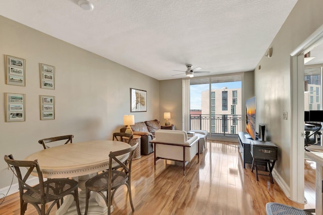 550 Okeechobee Blvd Unit 821, West Palm Beach, FL 33401 - dining space with light wood finished floors, a textured ceiling, a wall of windows, baseboards, and a ceiling fan