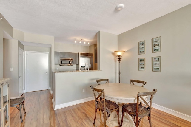 550 Okeechobee Blvd Unit 821, West Palm Beach, FL 33401 - dining area with light wood-style floors, a textured ceiling, and baseboards