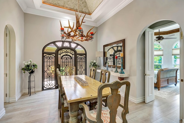 506 Corsair Dr, North Palm Beach, FL 33408 - dining area featuring arched walkways, a chandelier, ornamental molding, a tray ceiling, and a ceiling fan