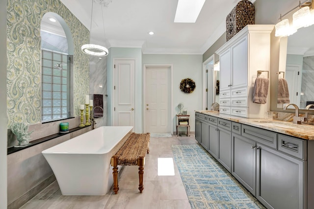 506 Corsair Dr, North Palm Beach, FL 33408 - full bathroom featuring crown molding, a soaking tub, double vanity, a skylight, and baseboards